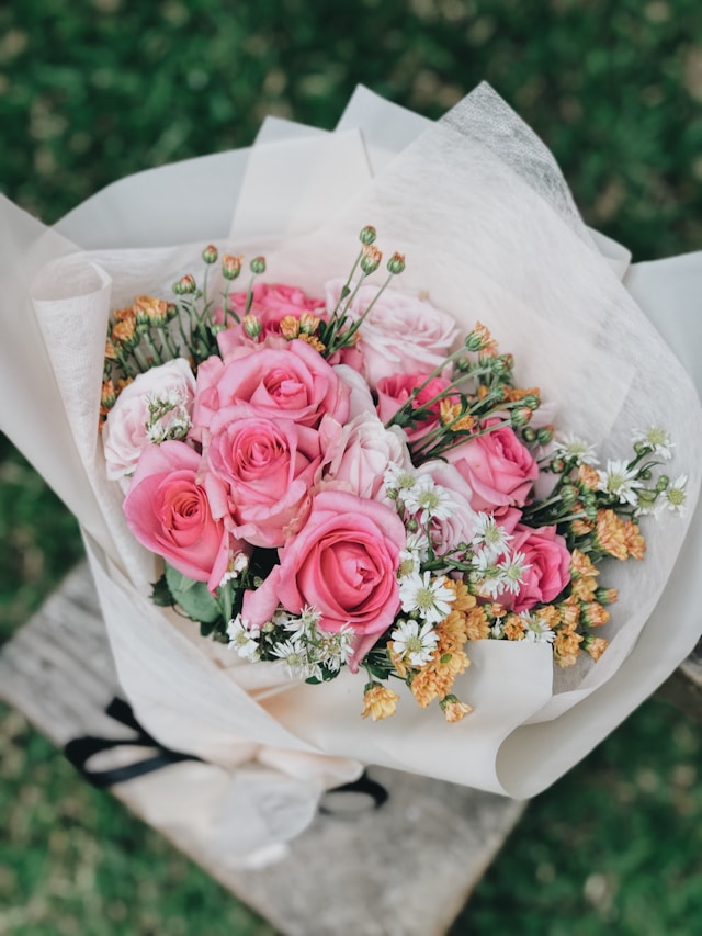 Pink floral arrangement displayed in a decorative gift box